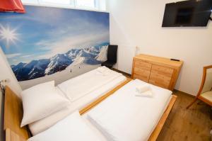 Residence Alpin - Studio-10 B by Four Seasons Apartments في كابرون: سريرين في غرفة جدارية على جبل