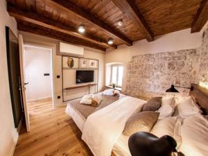 a bedroom with two beds and a stone wall at Villa Porta Maestra in Hvar