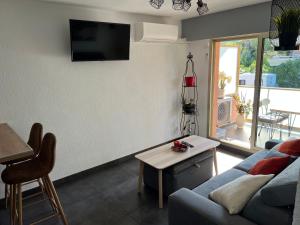 a living room with a couch and a table at « Le Andrea » in Cavalaire-sur-Mer