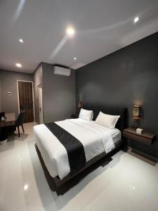 a bedroom with a large bed and a desk at Syailendra Hotel Syariah in Jepara