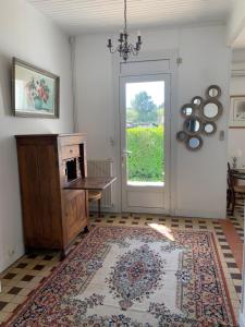 Habitación con puerta, mesa y alfombra en La Maison des Jardins en Naujac-sur-Mer