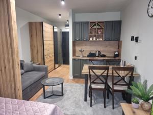 cocina y sala de estar con mesa y sofá en Apartman "PUZZLE" Bela Reka, Brzeće en Brzeće