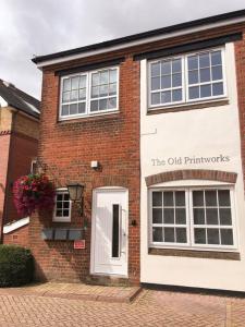 um edifício de tijolos com o velho letreiro da farmácia em No.1 The Old Printworks, Winchester em Winchester