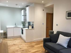 a living room with a couch and a kitchen at No.1 The Old Printworks, Winchester in Winchester