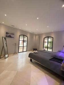 a large bedroom with a large bed and two windows at chambre d'hôte sur le golf de pont royal in Mallemort