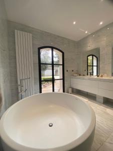 a large white bath tub in a bathroom at chambre d'hôte sur le golf de pont royal in Mallemort