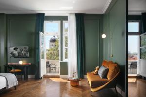 a bedroom with green walls and a couch and a bed at Almayer Art & Heritage Hotel and Dépendance in Zadar