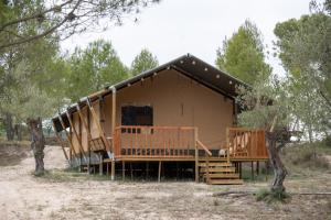 una casa grande con un gran porche en el bosque en Camping rural la Masia, en Cocentaina