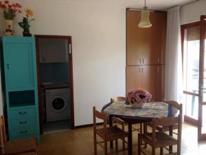 リド・ディ・イエゾロにあるJesolo Pineta - Appartamento Due Camere Matrimoniali Fronte Mareのキッチン(テーブル、椅子、洗濯機付)