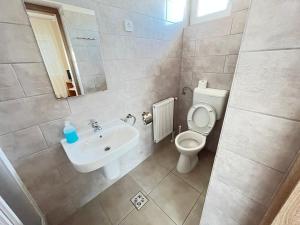 ein Badezimmer mit einem Waschbecken, einem WC und einem Spiegel in der Unterkunft Globus Guesthouse, Vendégház in Sormás