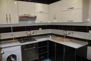 a kitchen with white cabinets and a sink at LE JASMIN RESIDENCE bord de mer in Hammam Sousse