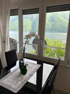 una mesa con un jarrón con una flor junto a una ventana en Casa Orchidea, en Oria