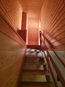 - un escalier en bois dans une chambre dotée de murs en bois dans l'établissement Apartament nad Zalewem, à Biszcza