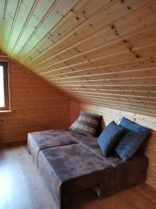 Cette chambre comprend un grand lit et un plafond en bois. dans l'établissement Apartament nad Zalewem, à Biszcza