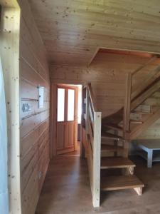 a wooden staircase in a log cabin with a door at Apartament nad Zalewem in Biszcza