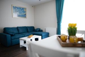 uma sala de estar com um sofá azul e uma mesa em BAJKA em Kragujevac