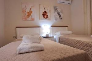 sypialnia z 2 łóżkami i ręcznikami w obiekcie Lovely Stay w Kalamácie