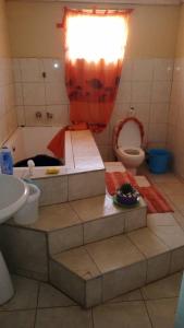 a bathroom with a tub and a toilet and a sink at Urban Oasis Retreat in Lusaka