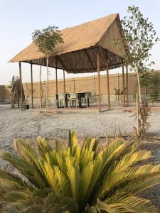 un pabellón con mesas y sillas en un campo en afnan farm, en Al Ḩamrānīyah