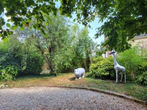 posąg żyrafy i nosorożca na podwórku w obiekcie La Demeure d'Othe w mieście Sormery