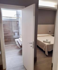 a small room with a bed and a bathroom at Hotel Royal Plaza in Rimini