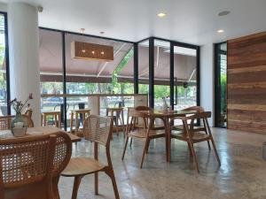 a dining room with tables and chairs and windows at The Peaberry Boutique Hotel in Chiang Mai