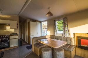 salon z kanapą i stołem oraz kuchnia w obiekcie Caravan With Decking At Highfield Grange In Essex Ref 26452ba w mieście Clacton-on-Sea