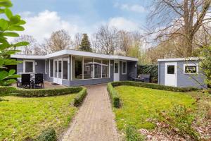 una pequeña casa azul con jardín en Bungalowpark De Bremerberg en Biddinghuizen