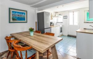 - une cuisine avec une table en bois et des chaises dans l'établissement Amazing Home In Opuzen With Kitchen, à Opuzen