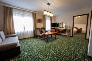 a hotel room with a couch and a table at Hotel Szelców in Lesko