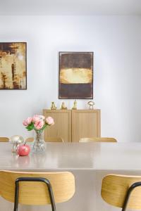 a table with chairs and a vase of flowers on it at Square-bnb - La Maison Pastèque à 8min de Disney in Montévrain