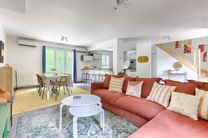 a living room with a red couch and a table at Square-bnb - La Maison Pastèque à 8min de Disney in Montévrain