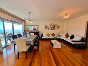 een woonkamer met een eettafel en een bank bij Apartamento grande familiar con vistas panorámicas al mar y la montaña in Funchal