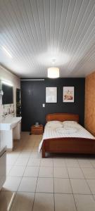 1 dormitorio con 1 cama grande y lavamanos en Chalet 38 m2, au calme reposant, près du puy /fou, en Saint-Pierre-des-Échaubrognes