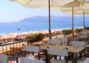 un restaurante con mesas y sombrillas en la playa en Savona Sant'antonio Mare Clima WiFi, en Savona