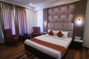 Säng eller sängar i ett rum på Hotel Idhayan Palace