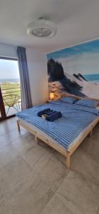 SunScape Corbu في كوربو: سرير كبير في غرفة نوم مع لوحة على الحائط