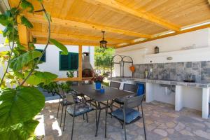 an outdoor kitchen with a table and chairs at House Duje in Plano