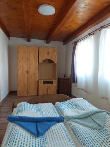 1 dormitorio con 1 cama grande y techo de madera en Orbán nyaralóház, en Kővágóörs