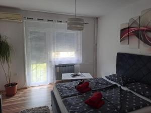 Un dormitorio con una cama con almohadas rojas. en Studio apartman BF en Slavonski Brod