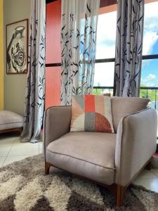 a living room with a couch and a window at the bib By Jevas in Dar es Salaam