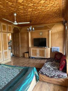 a room with a bed and a tv in a cabin at Taha Inn Home comfort in Srinagar