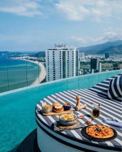 OceanDream Panorama Luxury Suites في نها ترانغ: طاولة طعام فوق مبنى بجانب الماء