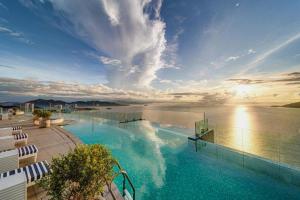 ein großer Pool neben einem Wasserkörper in der Unterkunft OceanDream Panorama Luxury Suites in Nha Trang