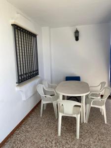 een witte tafel en stoelen in een kamer bij Chalet en Matalascañas in Matalascañas