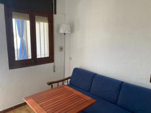 un soggiorno con divano blu e tavolo di Chalet en Matalascañas a Matalascañas