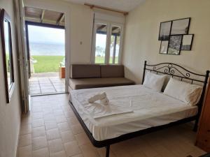 a bedroom with a bed and a view of the ocean at On the wave studios Spitakia sto kyma in Nikiti