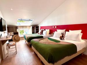 Duas camas num quarto com lençóis vermelhos e verdes em Hotel Le Provence - Restaurant Le Styx em La Palud sur Verdon