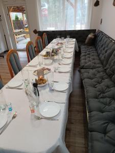 a long table with plates of food and a couch at Dom z Sauną i Jacuzzi dla dwóch rodzin Siłownia Kajaki in Gołdap