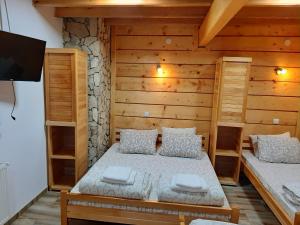 a bedroom with two beds and a flat screen tv at Vila Kula in Crni Vrh